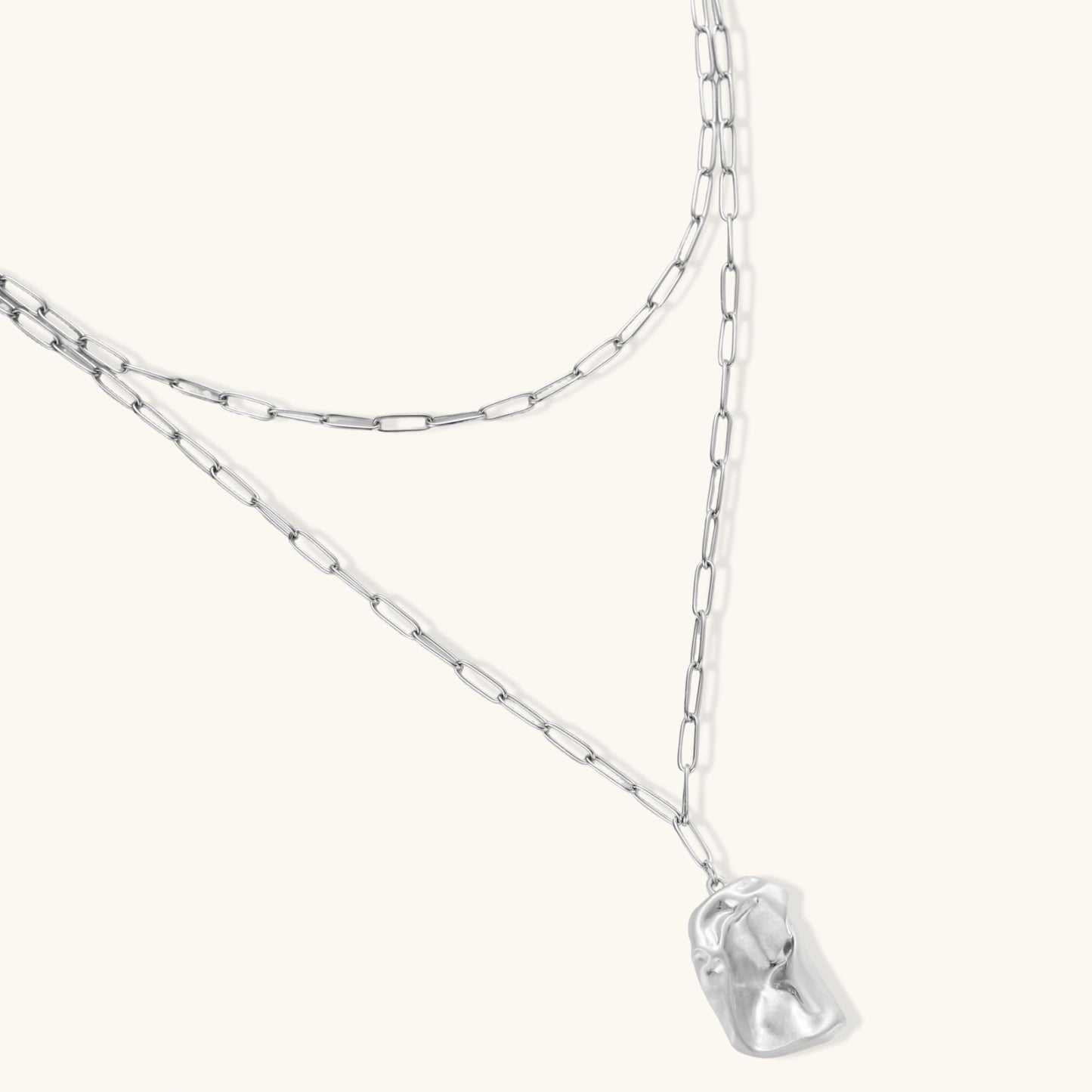 Modern textured hoop earrings and layered chain necklace with liquid metal pendant in silver and gold finishes.