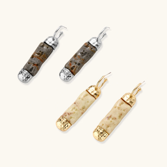 Elongated drop earrings with hammered gold caps and cream marbled resin bars on white background.